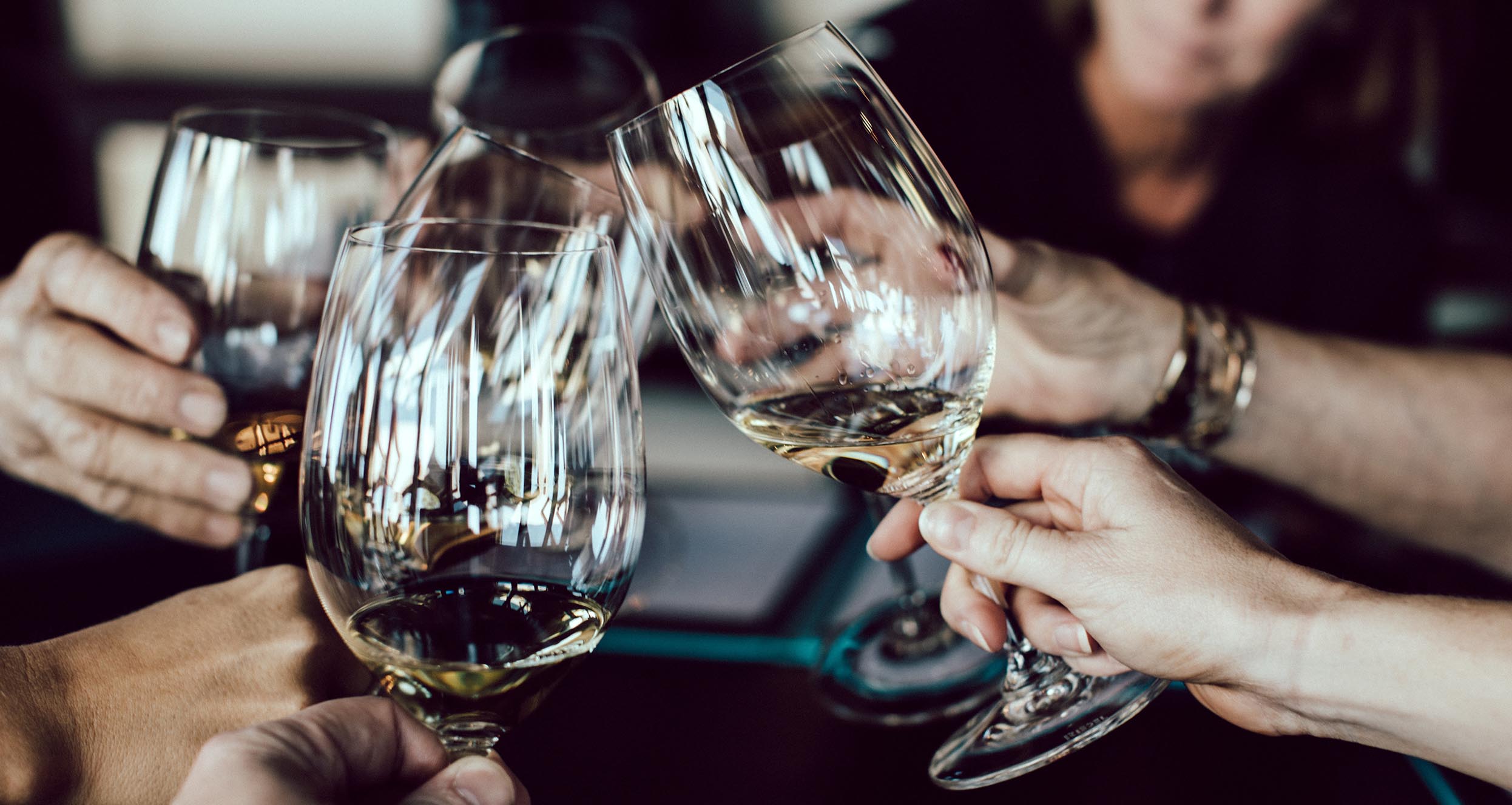 Five people making toast with wine glasses.